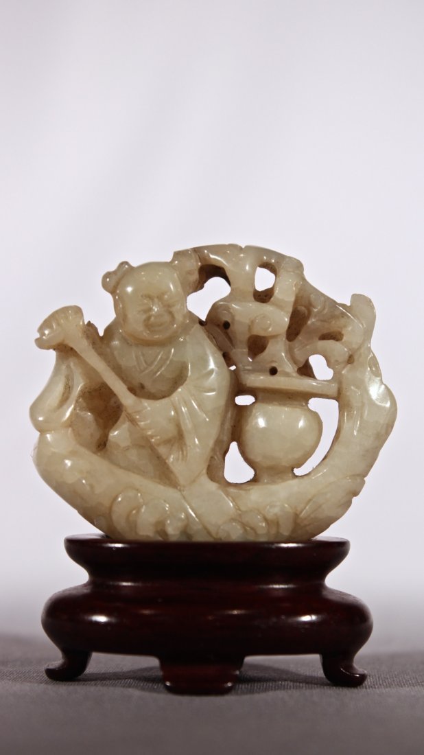 A CHINESE CREAMY-WHITE & BLACK JADE LADY LINGZHI RAFT: Ming Dynasty (1368–1644). A creamy-white crackled jade figure of a woman holding a paddle and steering a water raft with waves curling up from the bottom giving a sense of motion and travel, the wav