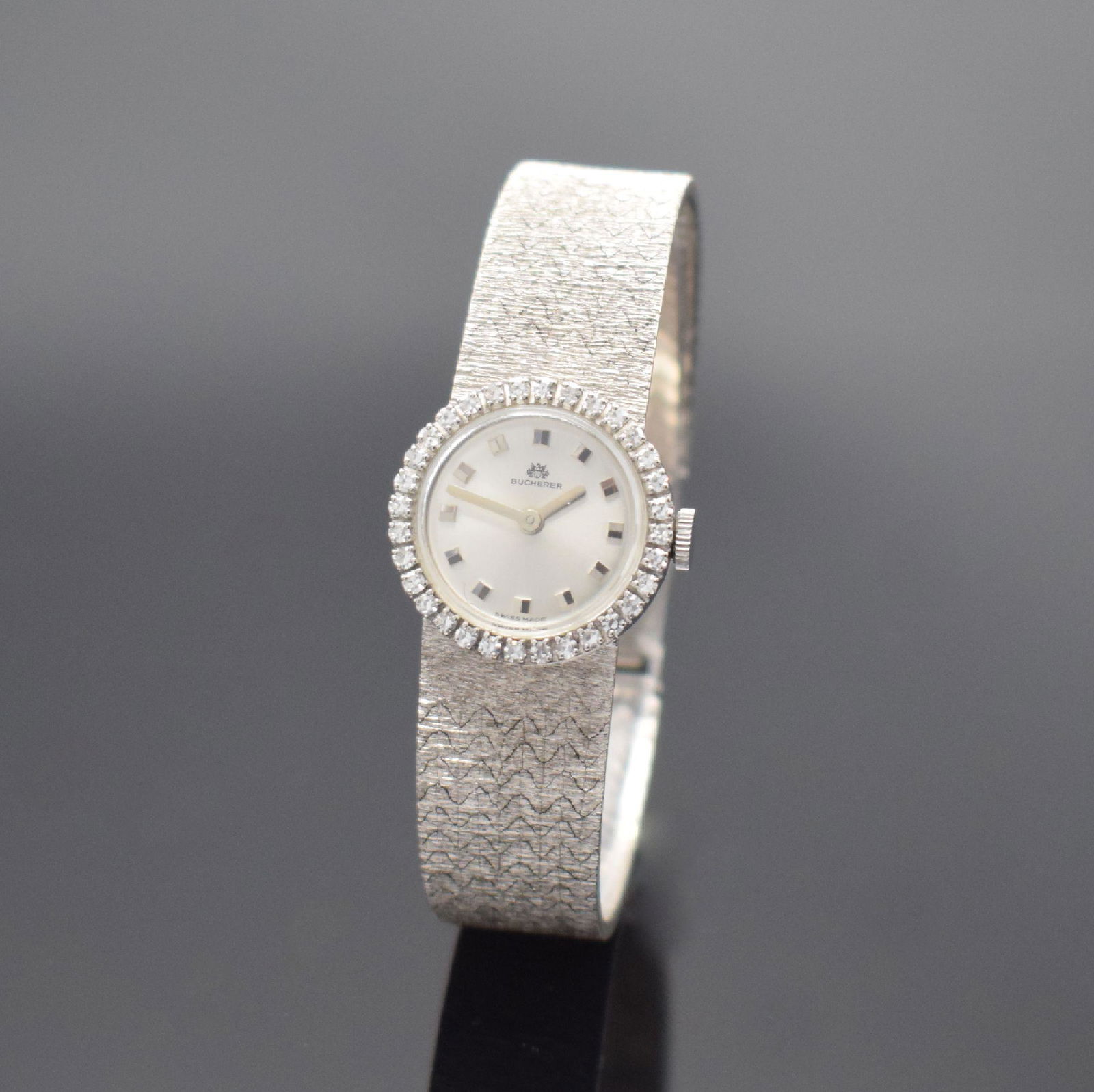 BUCHERER 18k white gold ladies wristwatch: BUCHERER 18k white gold ladies wristwatch with diamonds, Switzerland around 1965, manual winding, two-piece construction case, snap oncase back, diamonds set bezel, silvered dial with applied hour-ind