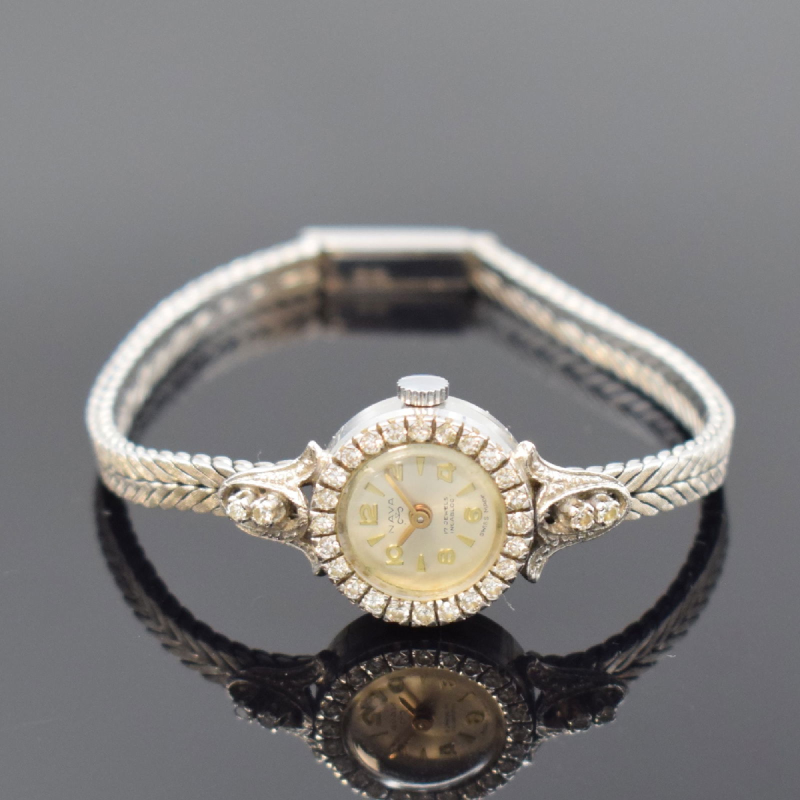 NAVA 18k white gold ladies wristwatch: NAVA 18k white gold ladies wristwatch, Switzerland around 1965, manual winding, case with gold bracelet 18k, snap on case back, bezel lavish set with diamonds, silvered dial with gilded indices and Ar