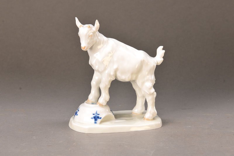 figurine, Meissen, 1.H.20th C.: figurine, Meissen, 1. H. 20th c., designed by Erich Hösel, goat on broken cup with blue onion pattern, painted, H.approx. 14.5 cm