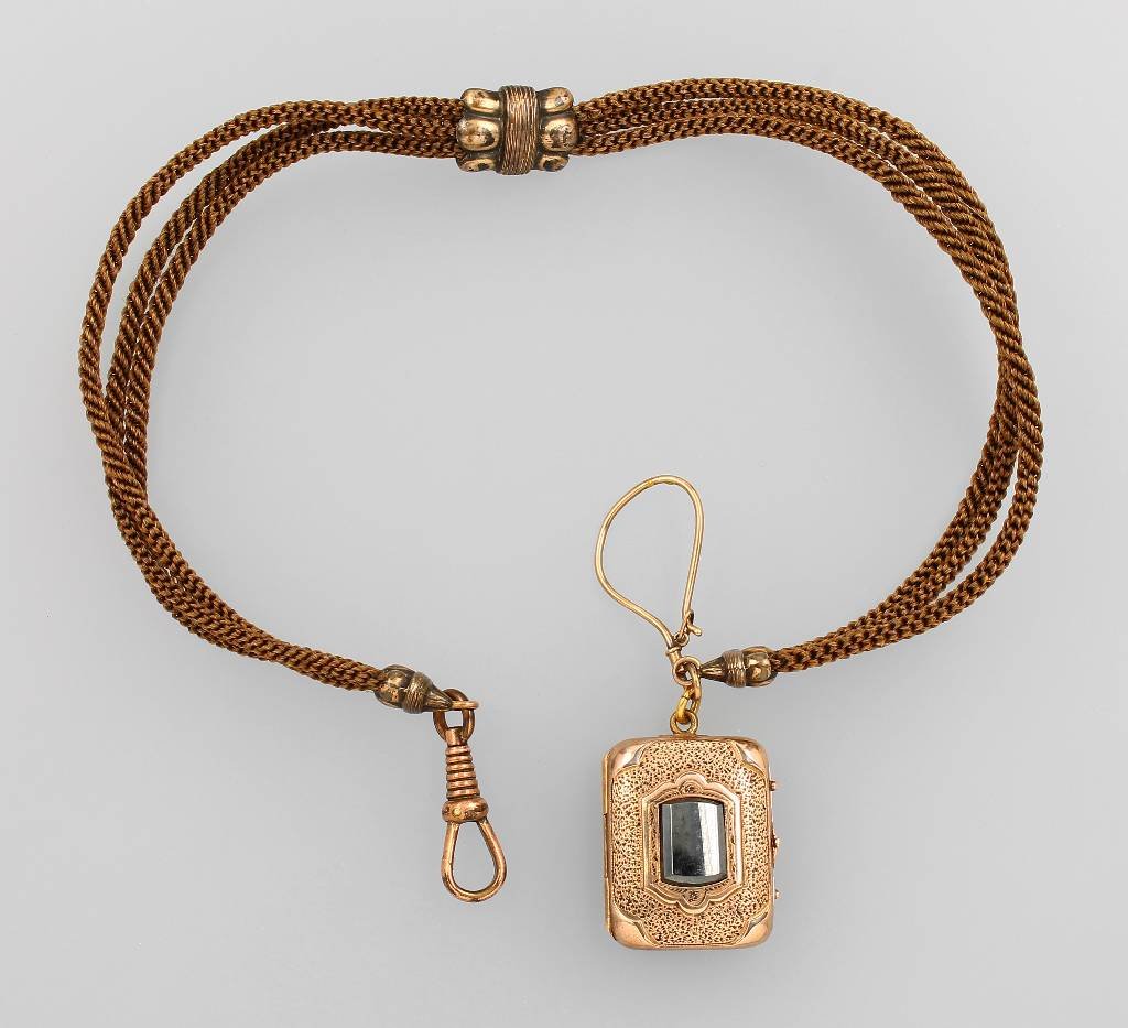 Locketpendant on hair braid, german approx. 1860/70: Locketpendant on hair braid, german approx. 1860/70 , with onyx- and hematite inlay, z. T. chased, pearl border decor, l. approx. 34 cm