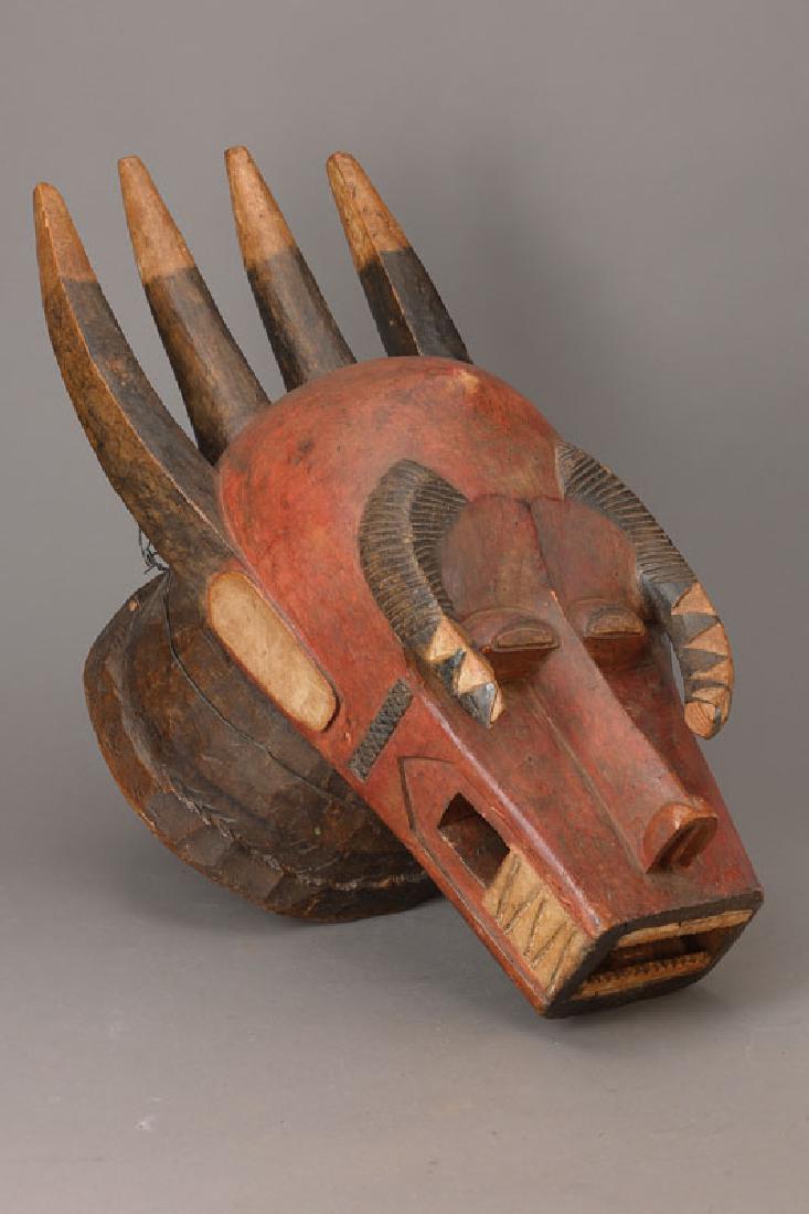 Large Helmet Mask: Large Helmet Mask 'bo num amuin', wood, red, black and white colour, with six horns, carved, two thereof enclose the face , minor dam., flaws at the horns, repaired row of teeth, 'bo nun amuin' means 