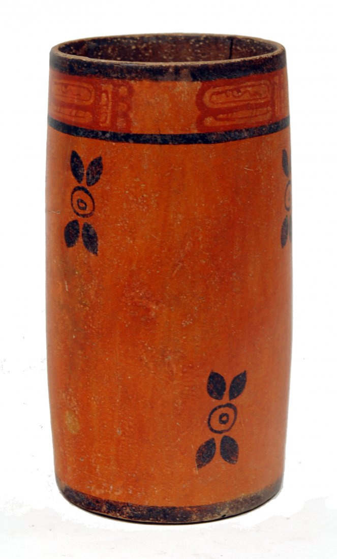 Pre-Columbian Mayan Pottery Cylinder Vessel: Late Classic, Ca. 600 to 900 AD. Ritual cylinder with bold graphic design in overall painted slips of orange and tan. Exterior with hieroglyphic symbols and winged devices in field. Height: 8-3/4 inch