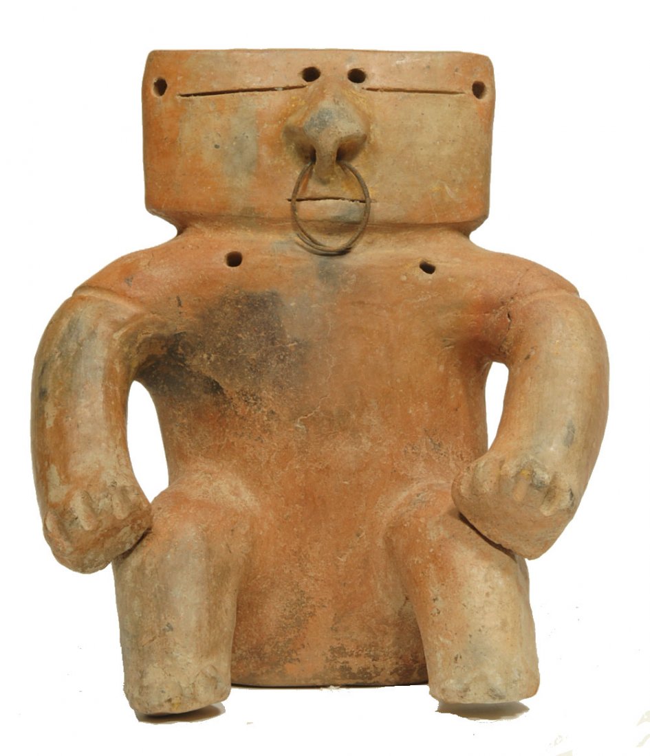 Pre-Columbian Quimbaya Retablo Pottery Figure: Colombia Ca. 1000 AD. Flat abstract seated figure with horizontal slit eyes and protruding nose with ancient bronze nose ring. 7”H. Multiple body piercing for attachments. Scattered mineral deposits