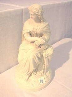 Composite Figural Seated Statue: 12" seated figural statue with damage. Overall good condition. Broken segment at hand (see photo) and some chips on base (see photo).