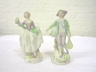 Pr. Occupied Japan Figurines.: This is a musical pair of figurines stamped Made in Occupied Japan. The man is 7-1/8" tall and carrying a musical instrument. The lady is 6-1/2" tall and holding her dress up at the side. Both