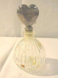 International Silver Perfume Bottle.: This bottle is 4" tall. The base is clear glass with a silver heart shaped stopper. The original label is on the bottom and says International Silver Co.