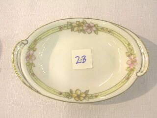 Small Nippon Floral Oblong Dish: 6-1/4" hand painted Nippon dish. There are 2 handle type areas on either end. The rim is gilded and there are 4 areas of painted flowers outlined in gilding.The base is stamped in blue with the