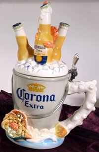 *CORONA CRAB/BUCKET STEIN: *CORONA CRAB/BUCKET STEIN….Porcelain, hand painted figural decoration. The focus of the 2nd edition to the Corona series is a crab and bucket design. A bucket of ice cold Corona Extra rests on a san