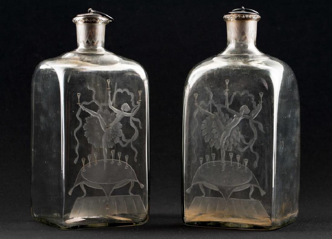 RARE PAIR OF ORREFORS ETCHED ART DECO DECANTORS: Matching pair of nudes balancing glasses while dancing on tables. Original silver and cork stoppers. Signed on base Orrefors "Gats"? 293 28 ES and 293 30. Remnants of original label. Height 8 inches. 