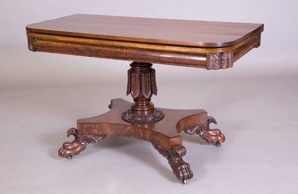 Philadelphia classical carved mahogany dinning tab: Philadelphia classical carved mahogany dinning table. The hinged rectangular top with rounded corners above a bolection apron with shaped and carved corners above an acanthus carved pedestal and incor
