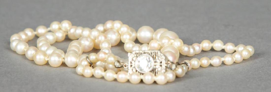 GRADUATING STRAND OF PEARLS with 1/2 CARAT DIAMOND: 18 inch strand of 3 1/2- 7 1/2 mm pearls. 14K white gold clasp set with 1/2 carat (I) 2 diamond