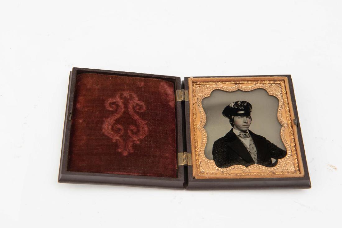 TINTYPE - DANDIFIED YOUNG MAN IN OFFICER'S TYPE CA: In decorated thermoplastic case. 3 3/4 x 3 3/8 x 13/16 inches.