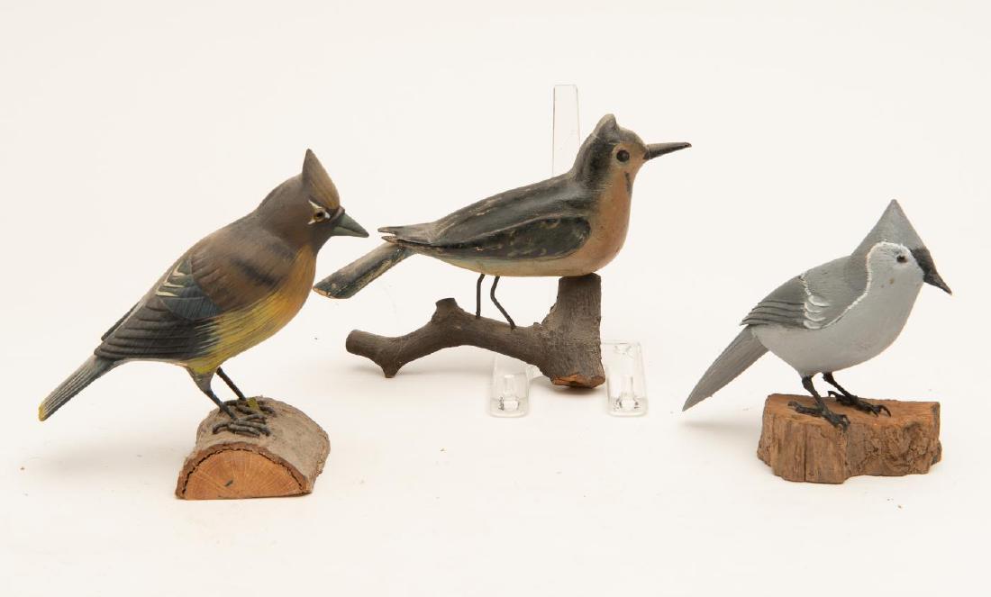 THREE CARVED AND PAINTED SONGBIRDS ON STANDS: Including a cedar waxwing and a woodpecker. 5 1/2 x 7 x 1 1/2 inches