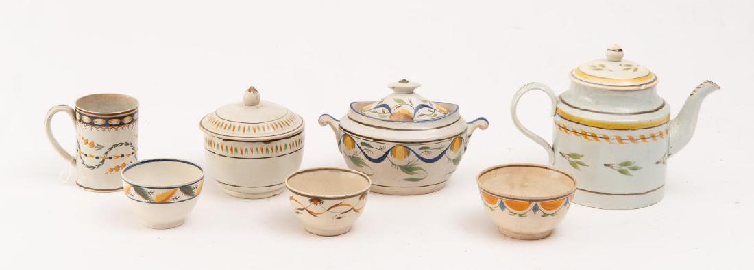 7 STAFFORDSHIRE PEARLWARE ENAMEL-DECORATED PCS.: Each painted in Pratt colors. Includes a teapot and lid, 2 covered sugar bowls, 2 handleless teacups, 1 small bowl, and 1 mug. Teapot: 7 inches high.