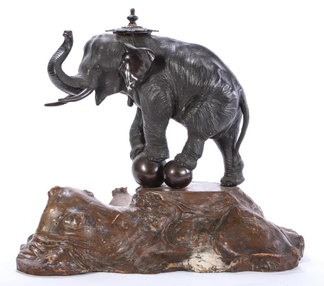 JAPANESE BRONZE ELEPHANT SIGNED IN CHARACTERS: Elephant works to balance on (2) balls. Cast specifically for a table lamp fixture (absent). Mounted to a burl wood root base. 18 x 24 x 16 inches.