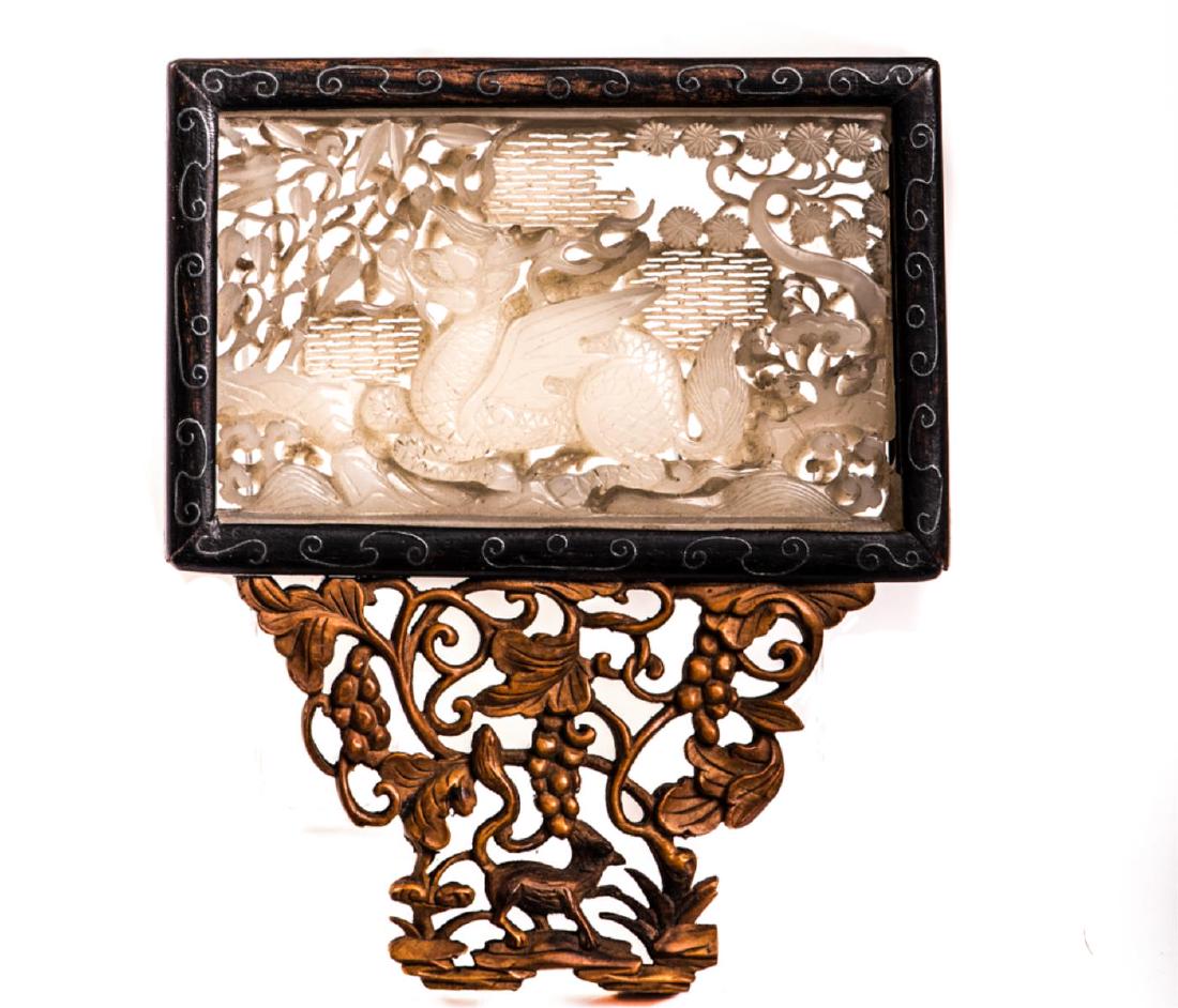 EARLY CHINESE WHITE JADE PLAQUE CARVED WITH DRAGON: Set into silver inlaid frame with attached sandal wood grape carved base. 2 x 3 1/2 inches (plaque). framed 4 3/4 x 4 inches (overall)