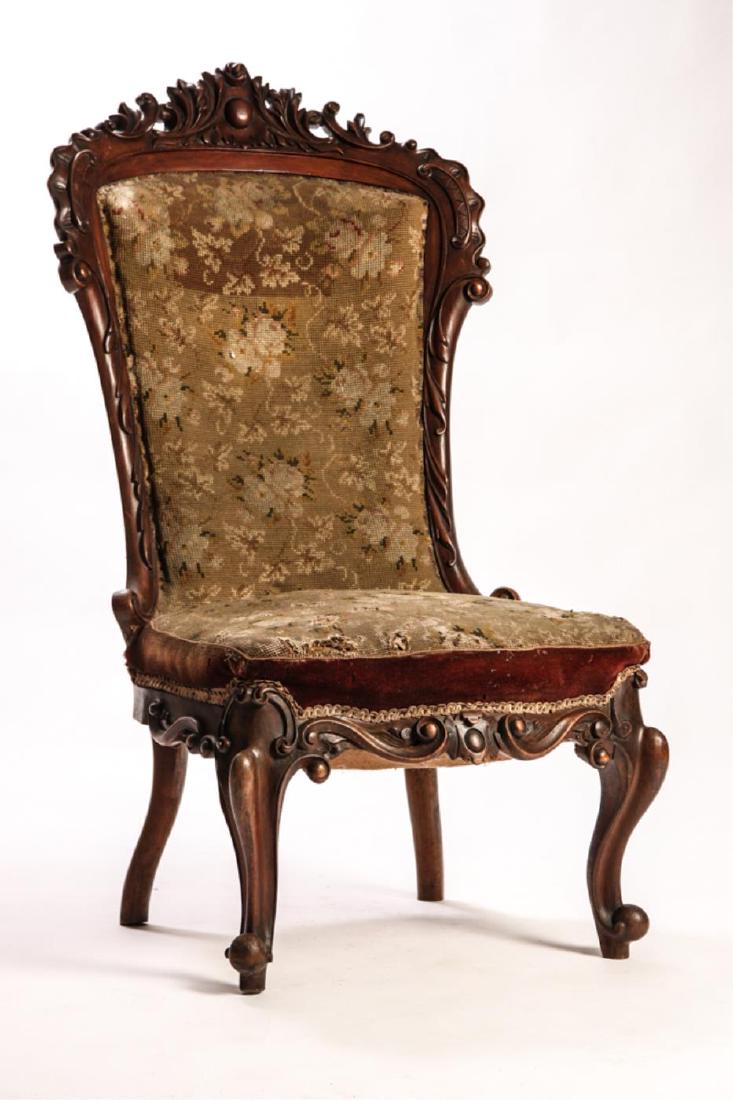ENGLISH LADIES VICTORIAN SLIPPER CHAIR: Crest, back, apron and legs, finely carved with foliated scrolls. Upholstered with embroidered wool. 44 1/2 x 24 1/2 x 28 inches.