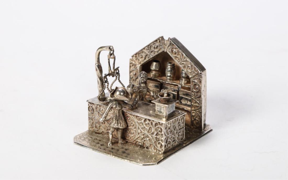 MINIATURE STERLING SILVER DUTCH BARISTA COUNTER: (19th c) "Patron at Counter" Coffee grinder spins and scales balance unmarked. 2 x 2 1/2 x 2 3/4 inches. 4.8 troy ounces.