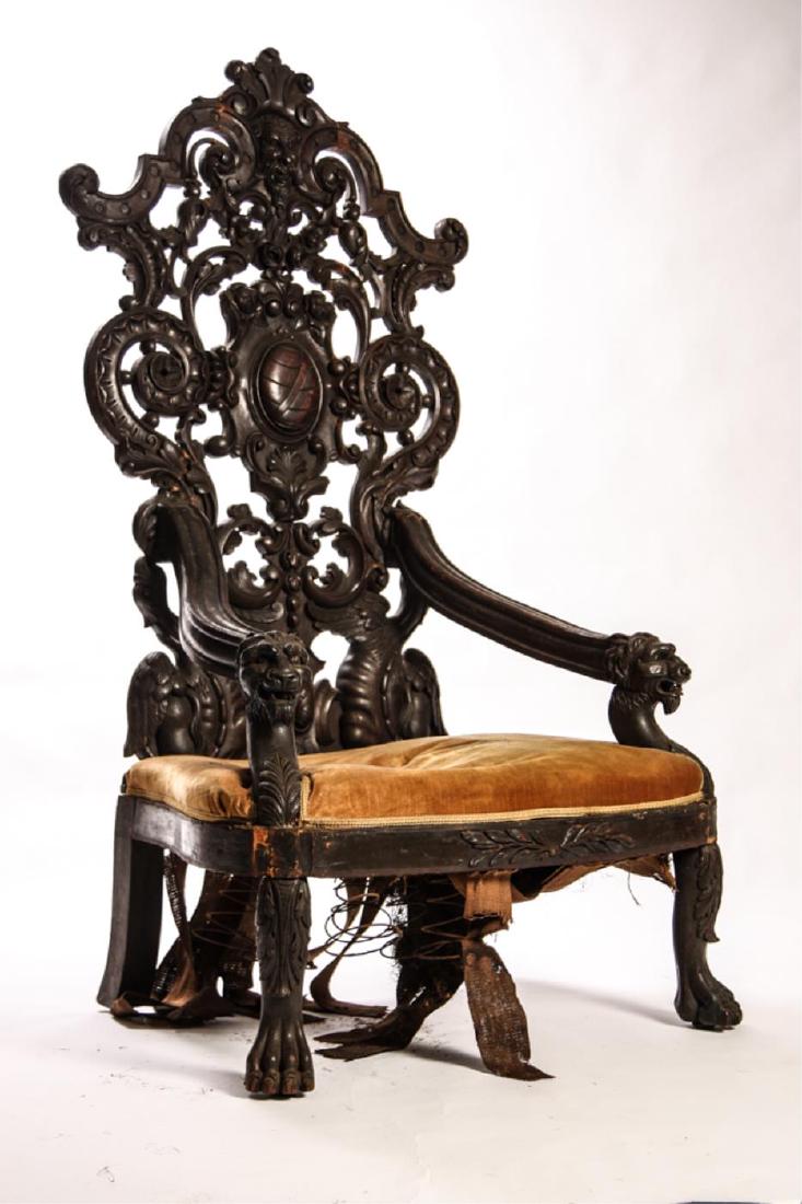 RENAISSANCE REVIVAL GREAT CHAIR: Elaborately carved and pierced with man's face, scrolls and flowers. Molded lion arms and feet carved with acanthus leaves. Upholstered seat with leaf carved apron. 70 x 36 x 21 inches