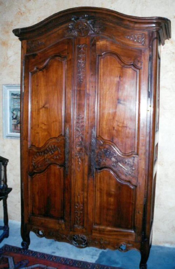 EXTRAORDINARY (18th c) FRENCH ARMOIRE: (4) Adjustable shelves and offset hinges. Molded arched crest carved with interlocking flaming hearts , bow and arrows surrounded by ribbons, acanthus leaves and bow. Conforming paneled doors are carv