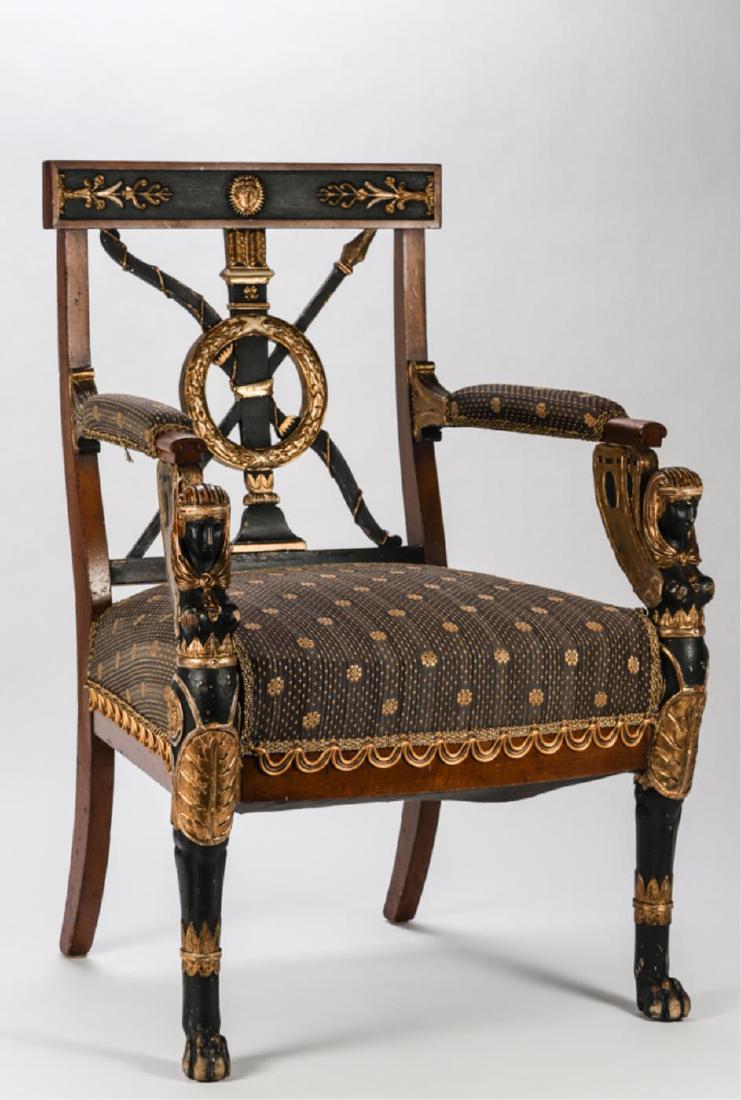 EGYPTIAN REVIVAL UPHOLSTERED ARMCHAIR circa 1820-1850: Crest rail carved with medallion and floral motifs, painted and gilt splat carved with bow, arrows, spear and laurel wreath. Arms terminate at legs with carved winged Isis and lion paw feet. 36 x 25 x