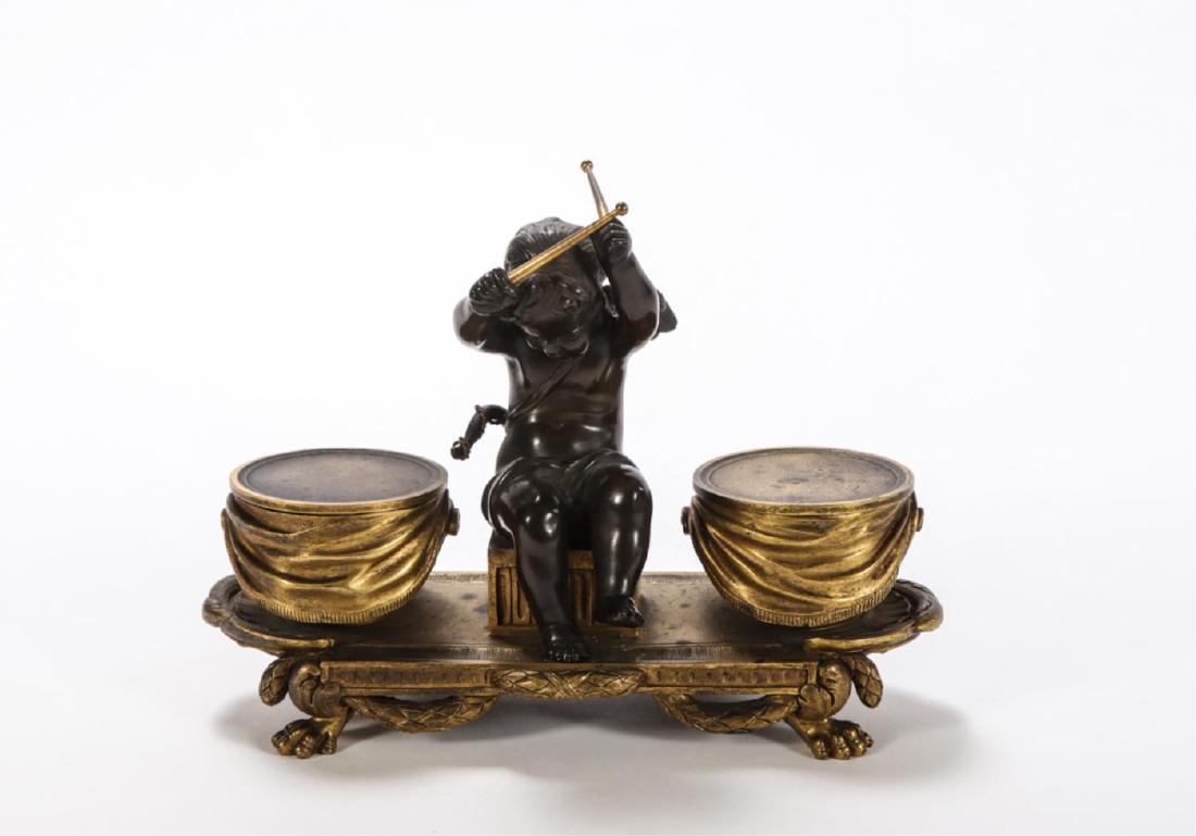 FIGURAL BRONZE INKSTAND with CHERUB BEATING DRUMS: Consisting of gilt bronze sander and inkwell (glass font absent). unmarked, after Sevres. 6 x 8 x 4 inches.