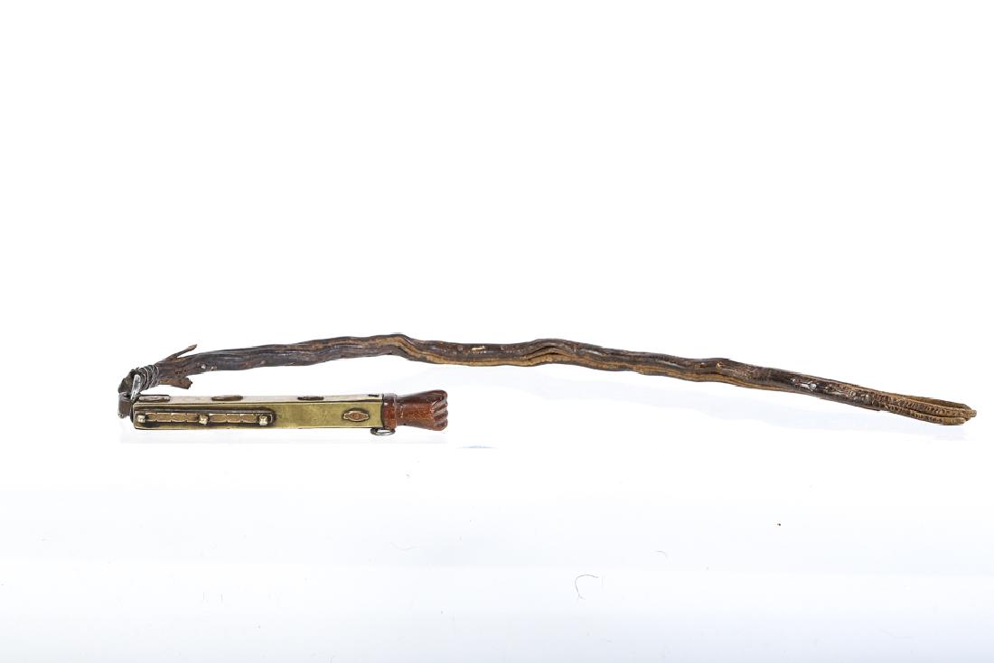 FOLK ART CAT-O-NINE TAIL WHIP: With interesting brass and wrought iron handle with fist carved pommel. 30 inches.