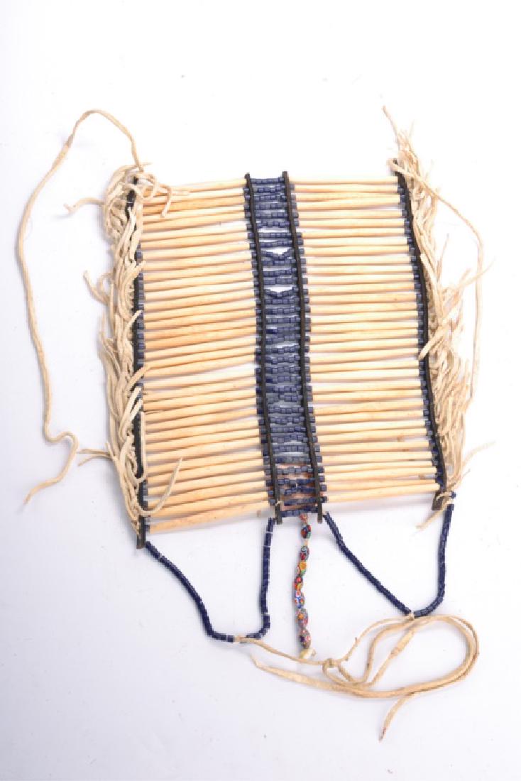 PLAINS INDIAN BUFFALO BONE BREAST PLATE: Flanked with horizontal rows of buffalo bone, beaded ends and center, 13 x 12 inches