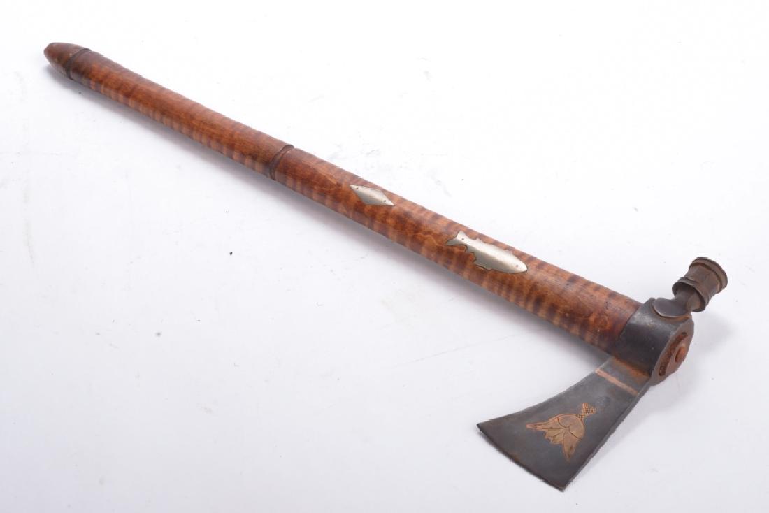 INLAID NATIVE AMERICAN PIPE TOMAHAWK: Late 19th century, blade having brass string and floral etched inlays, the tiger maple haft inlaid with metal fish and diamond, blade/pipe 6 inches long, haft 19.5 inches long