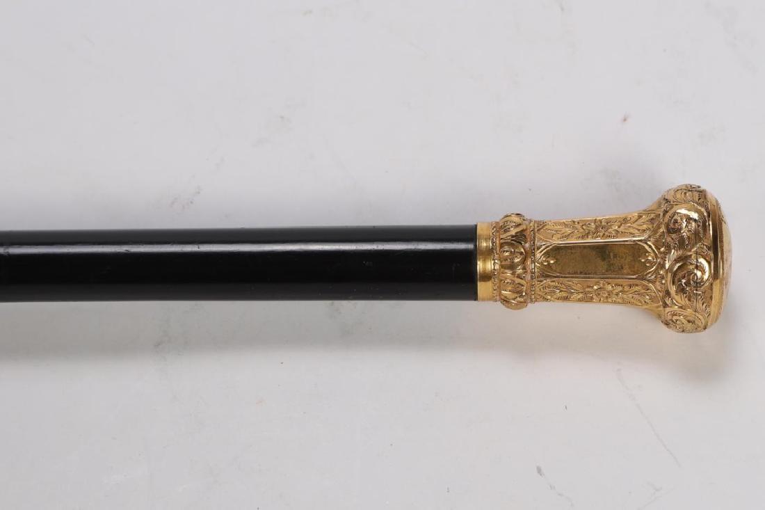 GOLD HANDLED GENTELMAN'S WALKING STICK: Knob handle bright cut scroll and floral motif, ebony shaft and rubber tipped ferrule. 35 1/4 inches