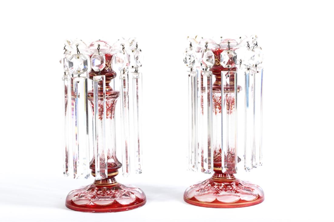 PAIR OF MOSER QUALITY BOHEMIAN GLASS LUSTERS: Antique Moser-style mantle lusters with red and white cut flash decoration against clear glass and highlighted in gold filigree. Base of prisms beautifully cut. 10 inches.