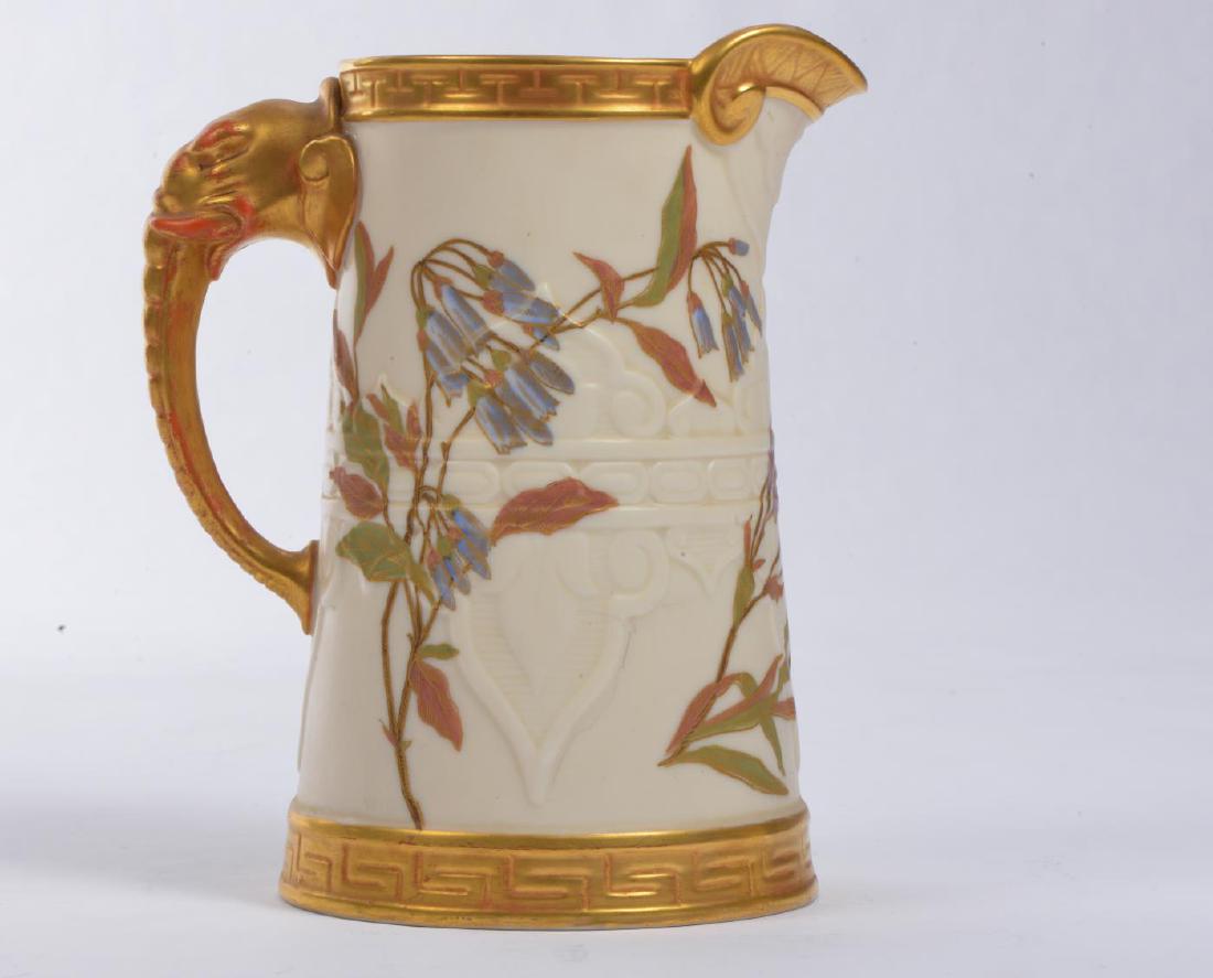 ROYAL WORCESTER GILT PORCELAIN PITCHER: Hand painted with sprays of flora and figural elephant trunk handle. signed. 7 1/2 inches.