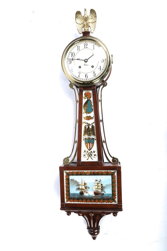 CHELSEA BANJO CLOCK "CONSTITUTION & GUERRIERE": Solid gilt full form eagle finial, 5 1/2 inch dial with chiming movement. Throat and lower panel reverse painted and highlighted with eglomise accents. 32 inches.
