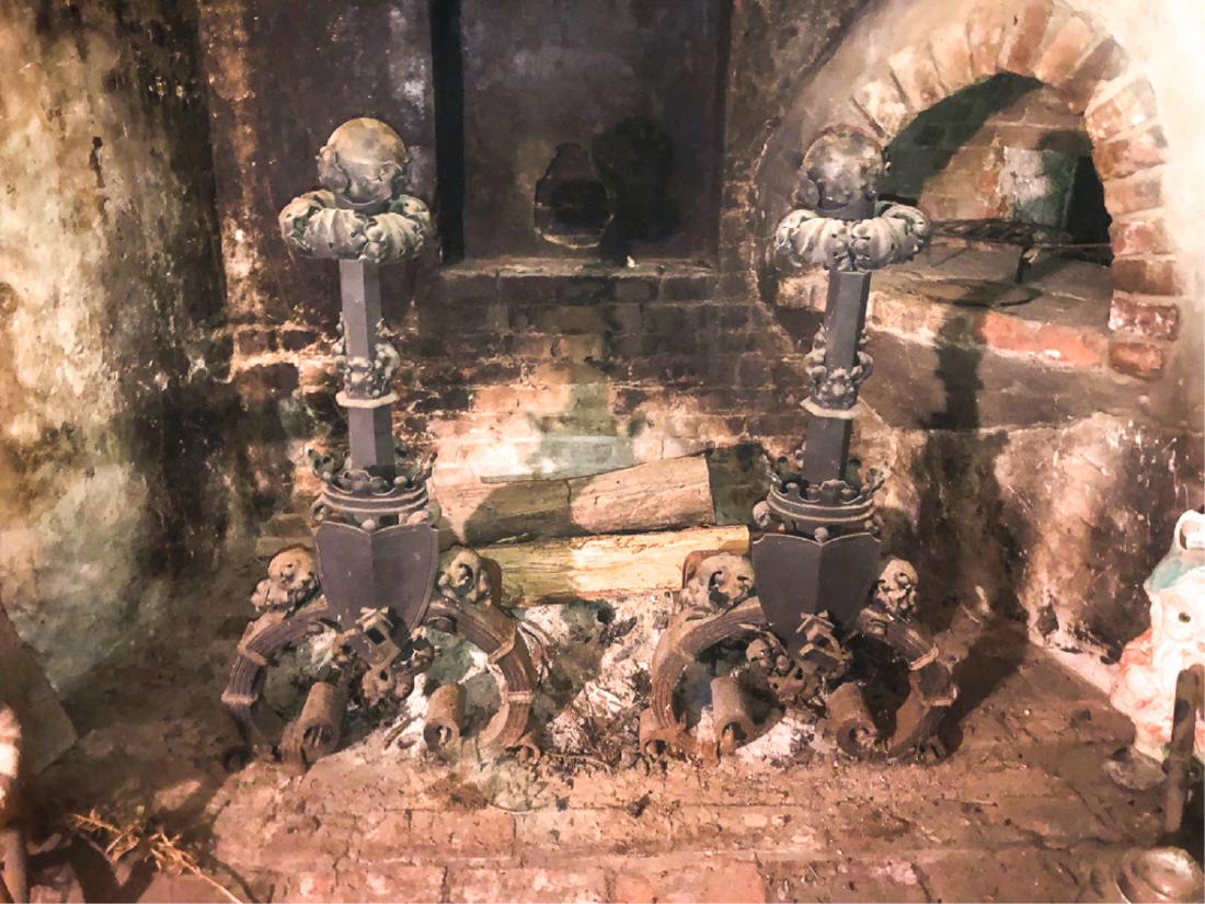 MASSIVE RENAISSANCE REVIVAL WROUGHT IRON ANDIRONS: Elaborate composition of cannon balls, acanthus leaves, crowns, shields, and faux iron laminations working into a scrolled framework. 35 inches
