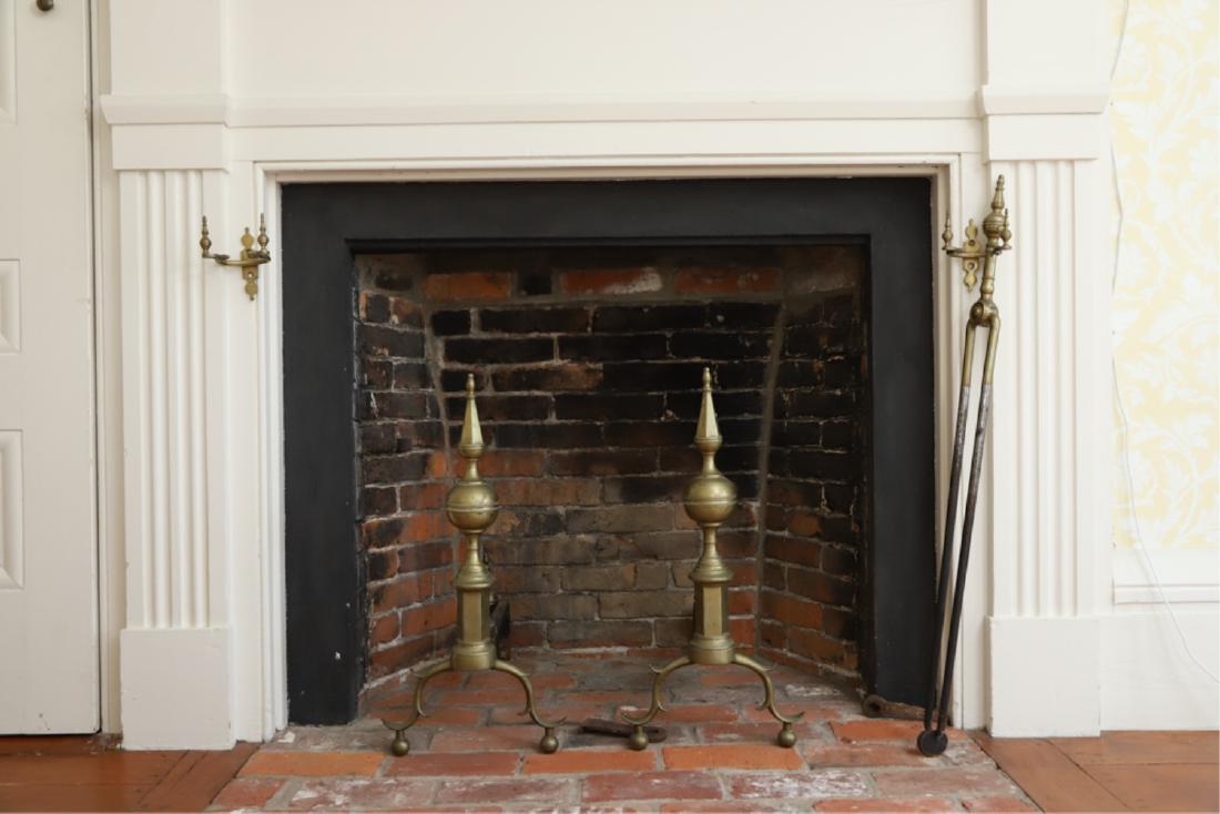 STEEPLE TOP BRASS ANDIRONS AND FIREPLACE EQUIPMENT: with double spurred cabriole leg and ball feet conforming log straps. Together with matching pair hooks and fireplace tongs (5 pieces). 22 x 10 3/4 x 20 inches