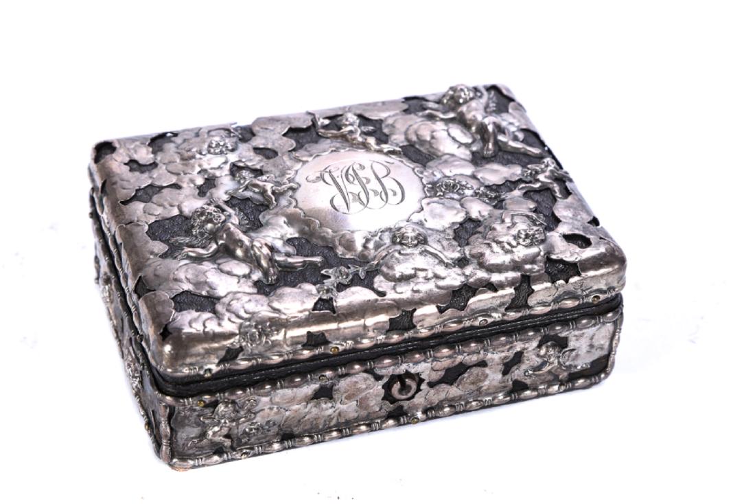 HAND CHASED STERLING SILVER JEWELRY BOX: Felt lined leather hinged box overlaid with hand chased flowers and cherubs. 1 3/4 x 5 x 4 inches.