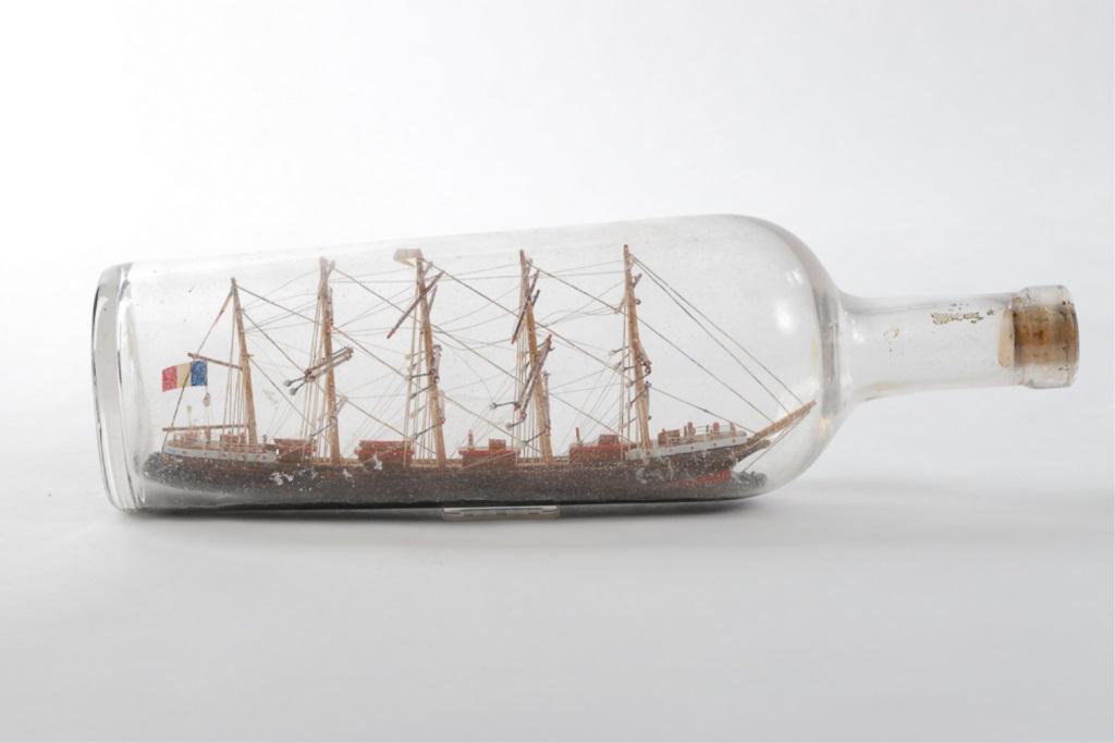 FIVE MAST SAILING SHIP IN A BOTTLE: With flag. Model is approx 8" and overall 12"