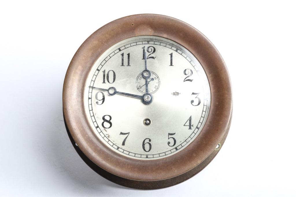 BRASS CHELSEA CLOCK: 7" in diameter overall. Clock appears to be running. Back of clock written in magic marker "CHIEF ENGINEER MOBIL MERIDIAN"
