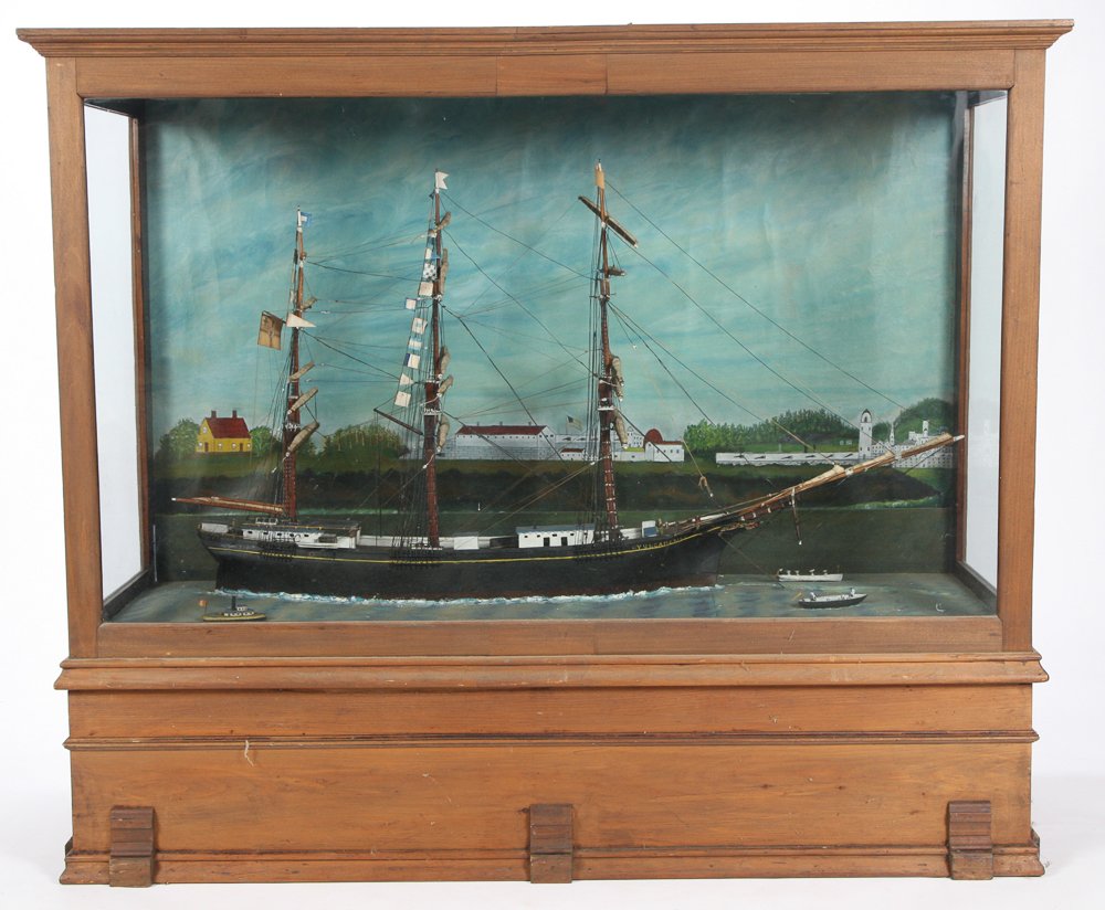 LARGE ANTIQUE CASED MODEL OF "YUNG AMERIKA": (3) Masted ship with deck fittings, deck houses and furled sails. Numerous pennants and flags. Rests in a painted ocean with (3) smaller craft approaching. The background is painted with a village, li