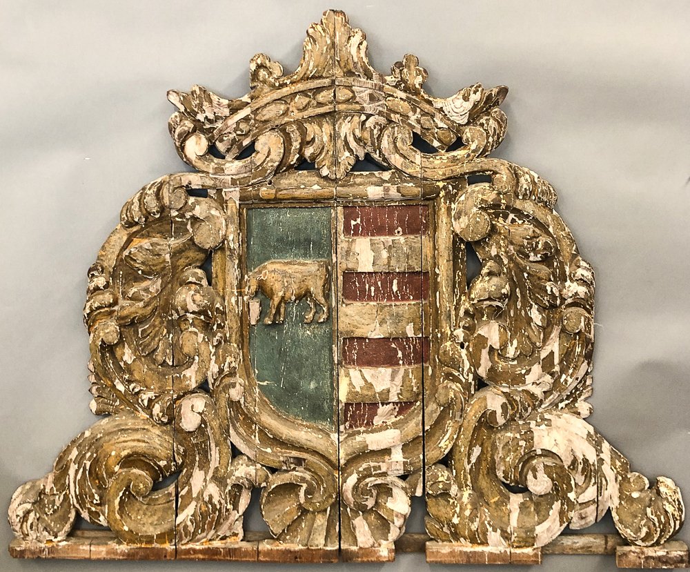 LARGE (19th c) CARVED & PAINTED COAT of ARMS: Shield elaborately surrounded by scrolls, acanthus leaves and shell. Painted with blue, and red and white striped fields. Blue half is carved in relief with a drinking horse and is surmounted by a cro
