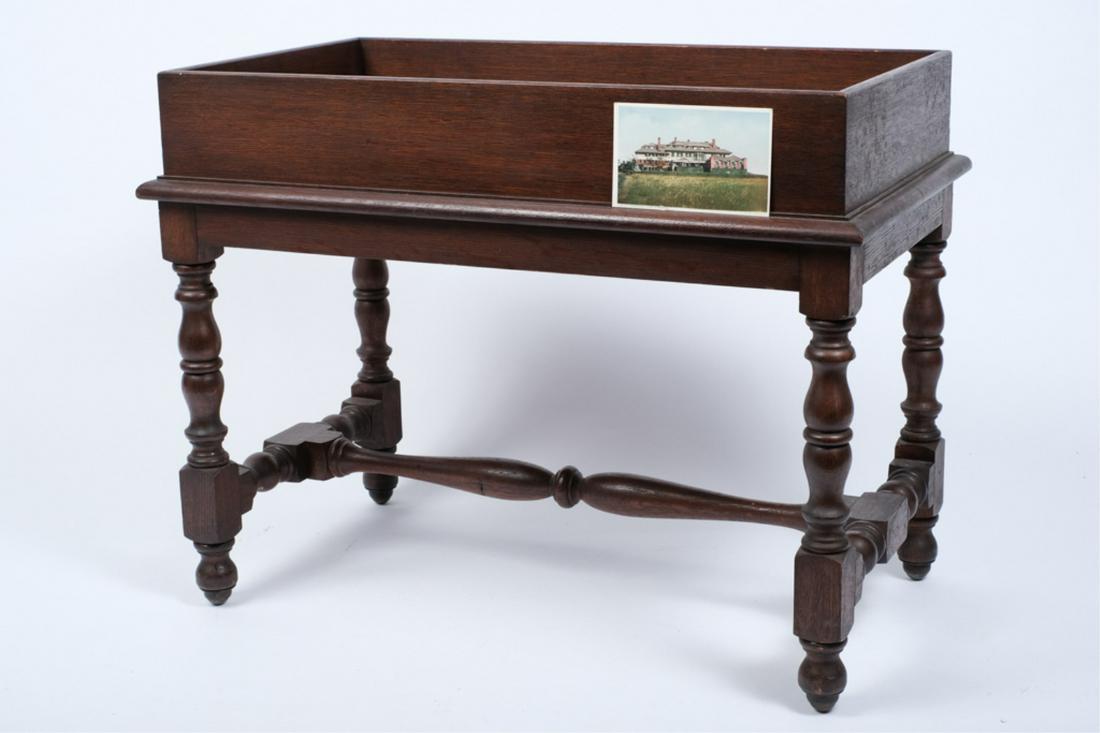 CUSTOM OAK TRAY TOP CADDIE FROM HAMMERSMITH FARM: Tray top over joined frame with castors. 21 1/2 x 28 x 16 inches. Together with (1) promotional brochure published by Sotheby Parke Bernet and a color postcard of Hammersmith Farm. Provenance: Hammers