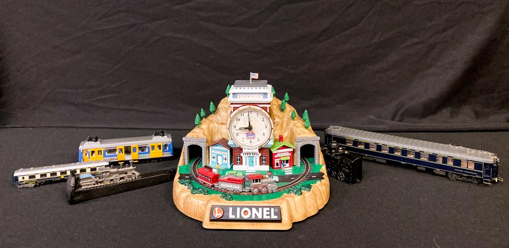 LIONEL CLOCK TRAIN SET AND ASSORTED CARS: RAM locomotive on a railroad spike, n gauge 1st class car, a restaurant car, a Euro Transit 73 electric bus and an "Orient Express" locomotive. Provenance: From the Estate of Michael Kenslea, Kittery,