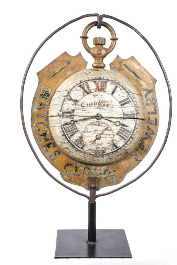 (19th c) JEWELERS TRADE SIGN "CHAPMAN": "Watch, Clocks, Jewelry" Cast iron bow and crown, painted wooden dial and gold painted sheet metal bezel. 29 inches. 38 x 25 inches (overall with stand)