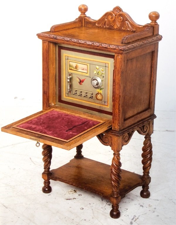 HERRING & CO SAFE SET IN IN OAK COMMODE: Cabinet with fan-carved double pediment crest rail, dolphin carved paneled door and frame of rope turned legs and lower shelf. 44 x 23 x 15 1/2 inches. (Purchased for $7,612 in 2003)