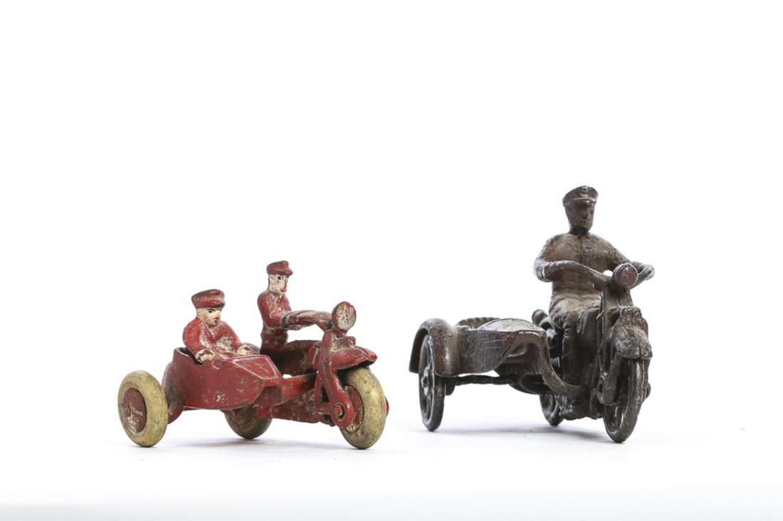 (2) CAST IRON TOY MOTORCYCLES W/ SIDECARS: Red example is in good condition with rubber tires intact. Gas tank marked HD. 4 1/4 inches The second passenger is detached from cycle. 5 inches. Passenger car is separated via clean break and will n