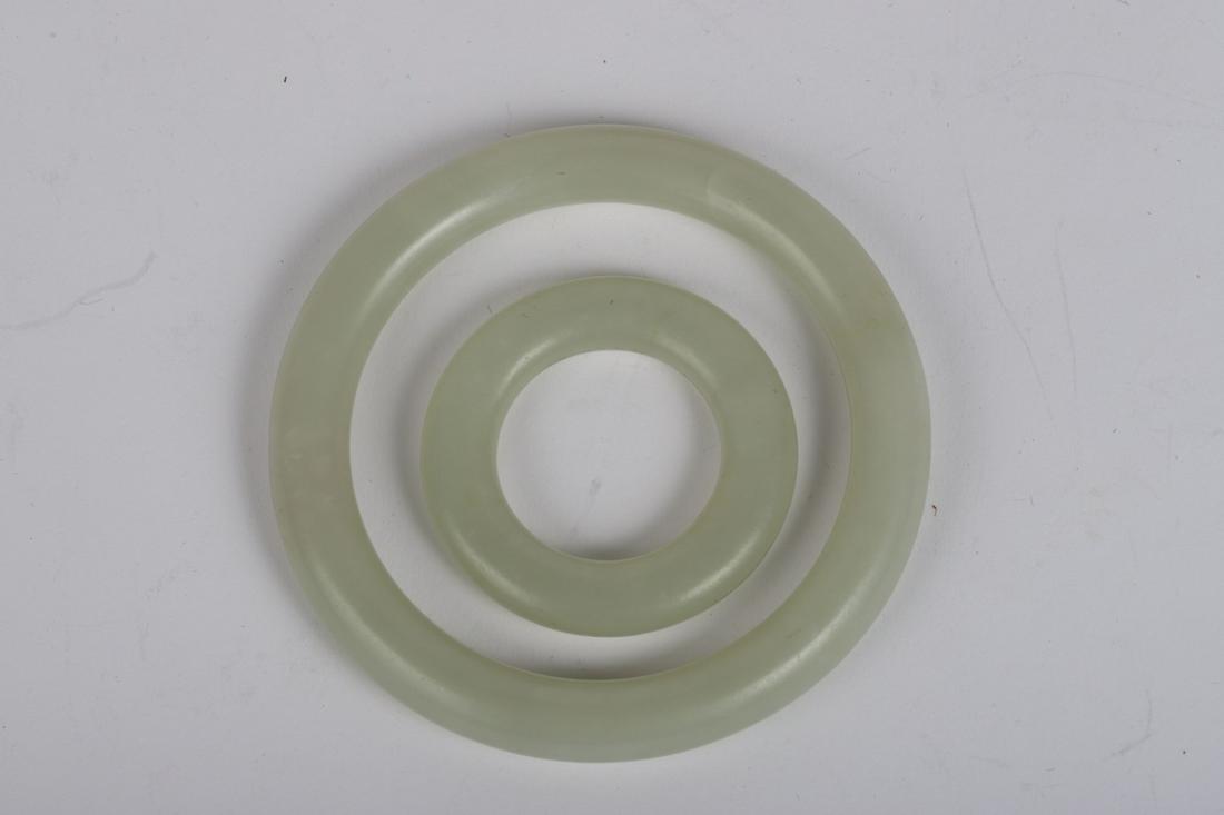 (2) CHINESE WHITE JADE RINGS: 3 and 1 1/2 inches in diameter. Condition: Good Temp No 228
