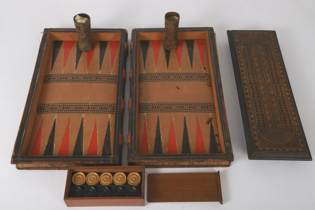 MARQUETRY INLAY CRIBBAGE BOARD & BACKGAMMON: Leather game board patented in 1884 complete with (15) checkers for checkers or backgammon. (2) leather shakers and (6) dice. 2 ½ x 14 x 8 inches. (closed). Closed it can be stored in a library “Ev