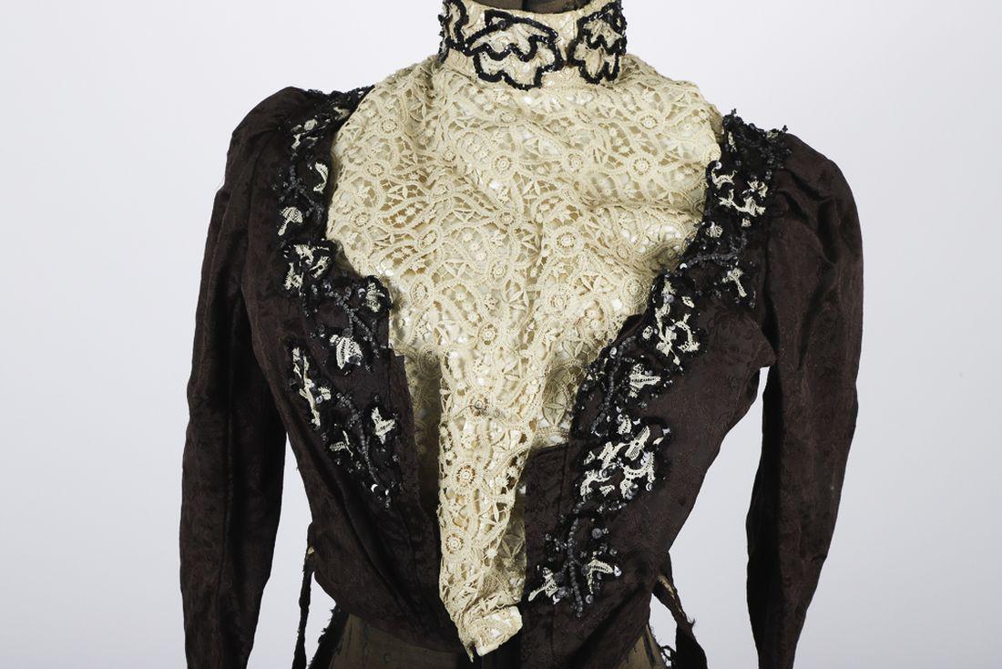 CORSETED VICTORIAN SILK DRESS TOP: Purple silk with floral toile pattern, black sequins and silk backed lace decolletage and cuffs. 17 inches from shoulder to belt.