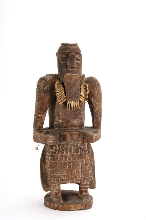 STANDING FIGURE OF ROBUSTLY BUILT HUNTER (c1945): Possibly Fang. Skirt draped in the back with the hide of a zebra. Face is adorn with cat claws. 17 inches